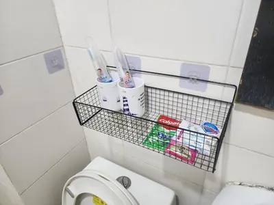 a bathroom with a toilet and a basket with toothbrushes at Bayport Luxhome in Manila