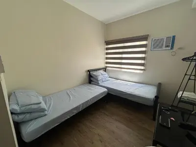 two beds in a small room with a window at M&L Condotel in Santo Domingo