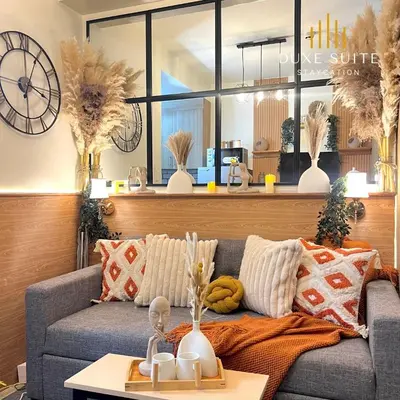 a living room with a couch and a clock at Aesthetic walking distance to MOA,near NAIA AIRPORT with NETFLIX,MINIVIDEOKE,BOARDGAMES-DUXE9 in Manila