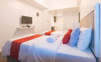 a hotel room with two beds and a television at RedDoorz at MPT Suites Test in Manila