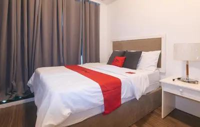 a bedroom with a bed with a red and white blanket at RedDoorz at MPT Suites Test in Manila