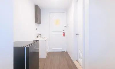 a kitchen with a black refrigerator and a white door at RedDoorz at MPT Suites Test in Manila