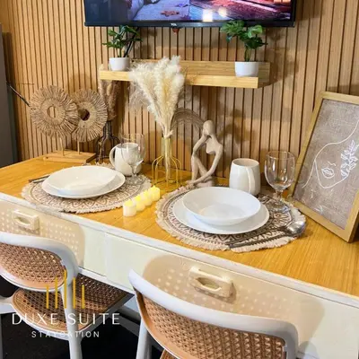 a table with plates and glasses and a woman on it at Aesthetic walking distance to MOA,near NAIA AIRPORT with NETFLIX,MINIVIDEOKE,BOARDGAMES-DUXE5 in Manila