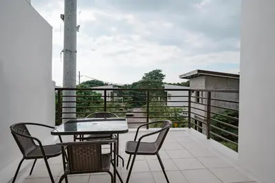 a patio with a table and chairs on a balcony at Picturesque 3BR home near Thunderbird, Overlooking in Binangonan
