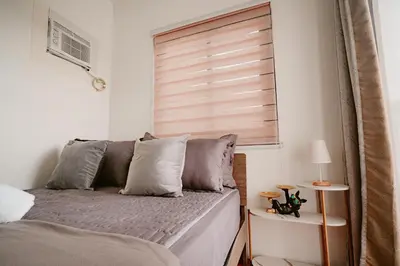 a bedroom with a bed and a window with blinds at Picturesque 3BR home near Thunderbird, Overlooking in Binangonan
