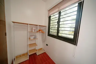 a small bathroom with a window and a shelf at Picturesque 3BR home near Thunderbird, Overlooking in Binangonan