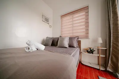 a white dog laying on a bed in a bedroom at Picturesque 3BR home near Thunderbird, Overlooking in Binangonan