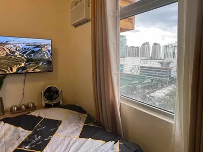 a bedroom with a bed and a window with a view at Aesthetic Studio Unit at Deca Cubao QC in Manila