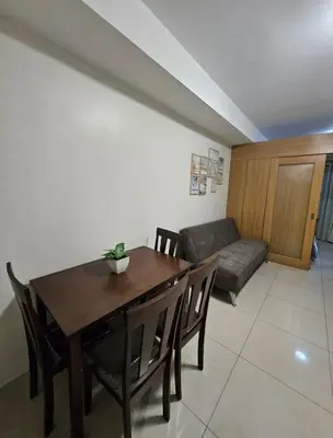 a living room with a table and chairs and a couch at Staycation with Netflix in Shell Residences in Manila