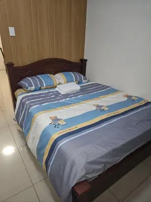 a large bed with blue and white blankets and pillows at Staycation with Netflix in Shell Residences in Manila