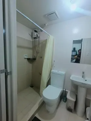 a bathroom with a toilet and a shower and a sink at DongStay in Bayabasan
