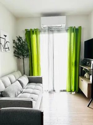 a living room with green curtains and a couch at Casa Dreamer in Taytay