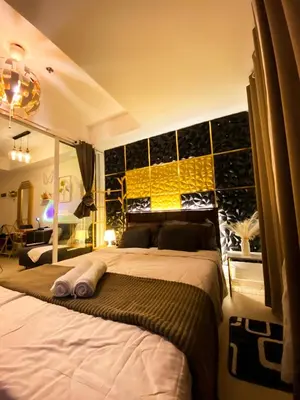 a bedroom with a large bed with a yellow wall at Hiraya Vacation at Azure Urban Resorts in Manila