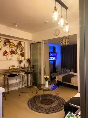 a living room with a bed and a table at Hiraya Vacation at Azure Urban Resorts in Manila