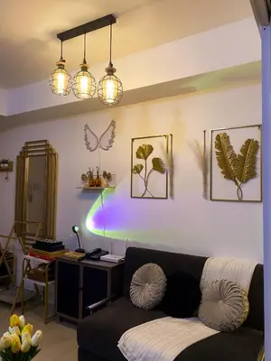 a living room with a couch and a desk with lights at Hiraya Vacation at Azure Urban Resorts in Manila