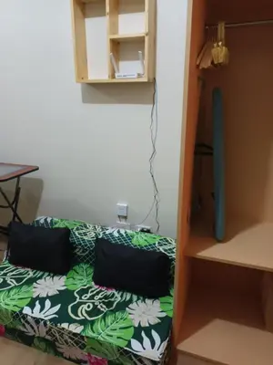 a small room with a bed and a table at Nature Green Room Paseo Verde at Calle Real in Manila
