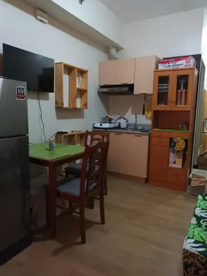 a kitchen with a table and chairs and a refrigerator at Nature Green Room Paseo Verde at Calle Real in Manila