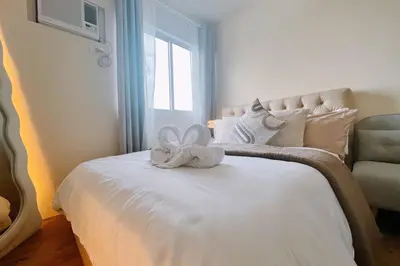 a bedroom with a bed with a white flower on it at Cozy Elegance Staycation in Silang