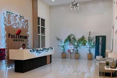 a man sitting at a reception desk in a lobby at Cozy Elegance Staycation in Silang