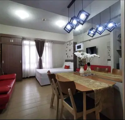 a room with a dining table and a bedroom at 150 Newport Boulevard - North Wing in Manila