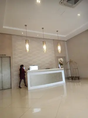 a person walking in a lobby with a reception desk at 150 Newport Boulevard - North Wing in Manila