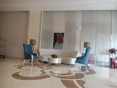 a lobby with a couch and chairs and a painting at 150 Newport Boulevard - North Wing in Manila