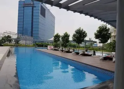 a large swimming pool with chairs and a building at Condo staycation in SLP Bangkal Makati in Manila