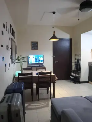 a living room with a dining room table and a tv at Condo staycation in SLP Bangkal Makati in Manila