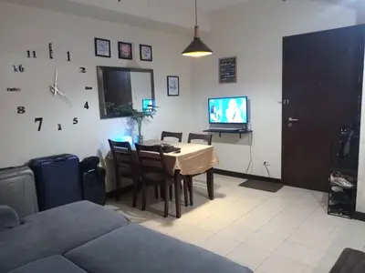 a living room with a table and a television at Condo staycation in SLP Bangkal Makati in Manila