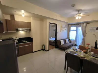 a kitchen and living room with a table and a couch at Condo Unit Near Manila Bay, US Embassy & Iconic Tourist Spots in Manila