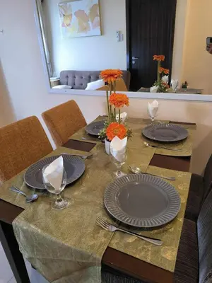 a table with plates and flowers on top of it at Condo Unit Near Manila Bay, US Embassy & Iconic Tourist Spots in Manila