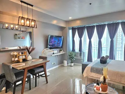 a living room with a table and a dining room at Ashley's Chamber at Soho Central across Shangrila Mall in Manila