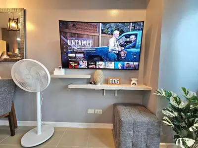 a living room with a flat screen tv on a wall at Ashley's Chamber at Soho Central across Shangrila Mall in Manila