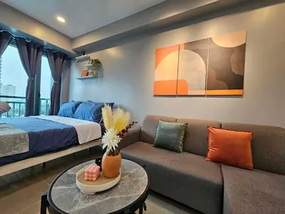 a living room with a couch and a bed at Ashley's Chamber at Soho Central across Shangrila Mall in Manila