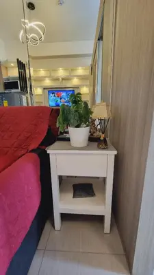 a room with a bed and a table with a plant on it at Carps Staycation in Manila
