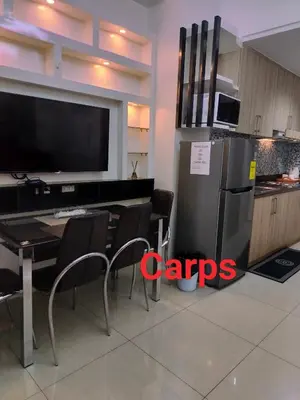 a kitchen with a refrigerator and a table with chairs at Carps Staycation in Manila