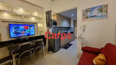 a living room with a red couch and a tv at Carps Staycation in Manila