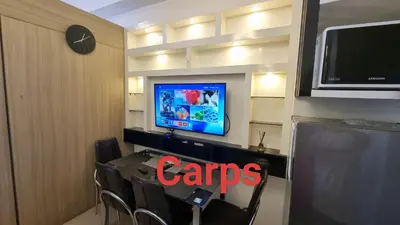 a room with a table with chairs and a tv at Carps Staycation in Manila