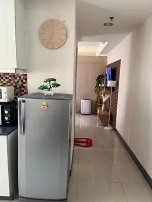 a kitchen with a refrigerator and a clock on the wall at Sea Residences Spacious Unit by Ellenn in Manila