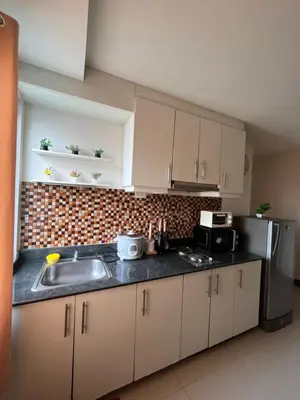 a kitchen with a sink and a refrigerator at Sea Residences Spacious Unit by Ellenn in Manila