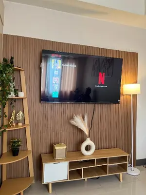 a living room with a television on a wall at Sea Residences Spacious Unit by Ellenn in Manila