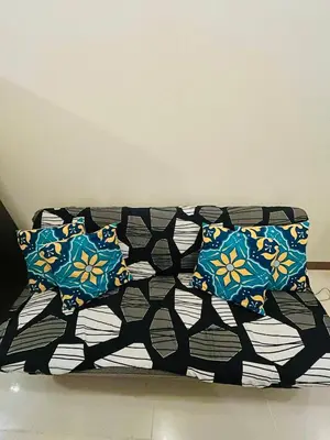 a bed with blue pillows on it in a room at Zeke's Staycation in Manila