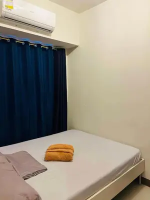 a bedroom with a bed with a blue curtain at Zeke's Staycation in Manila