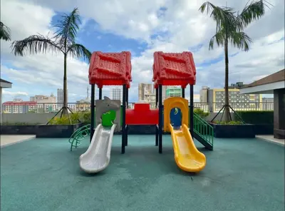 a playground with three different colored slides on a roof at Zeke's Staycation in Manila