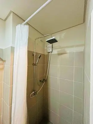 a shower in a bathroom with a shower curtain at Zeke's Staycation in Manila
