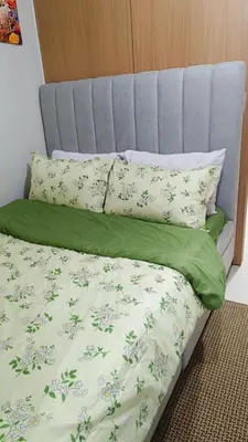 a bed with green and white sheets and pillows at Cozy Space at Red Makati City in Manila