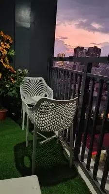 a wicker chair sitting on a balcony with a view at Cozy Space at Red Makati City in Manila