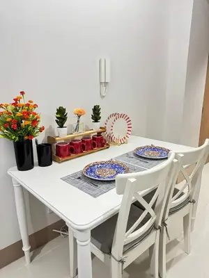a white table with two chairs and plates on it at Unistay Shore 3 Tower 2 10th floor near MOA and AIRPORT in Manila