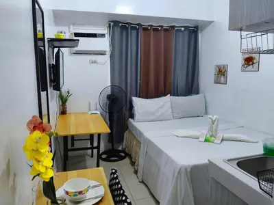 a small room with a bed and a kitchen at g and A condotels in Manila