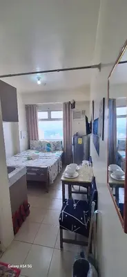 a room with two beds and a table in it at g and A condotels in Manila